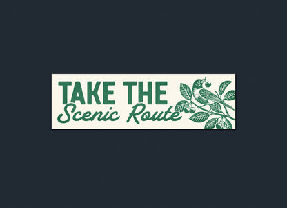 Decorative sign with 'Take the Scenic Route' text and nature-themed design on a dark background